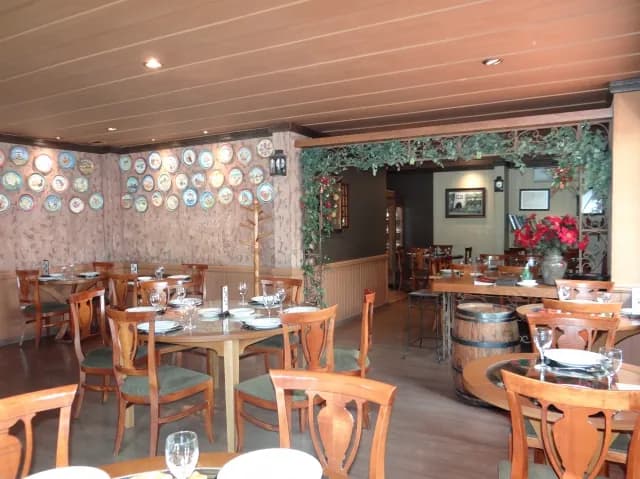 Salão do Nonno Mio em Gramado, com mesas e pratos decorativos nas paredes
